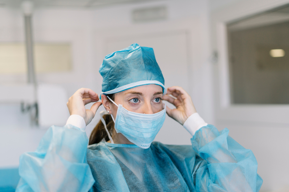 Young,Beautiful,Woman,,Nurse,,Doctor,,In,Mask,,White,Blue,Background.dressing paura contagio Cassazione
